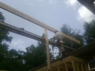 Carpenter setting a ridge beam over a new addition frame — Ice Dam Removal by Roofing Brothers in Sylvester