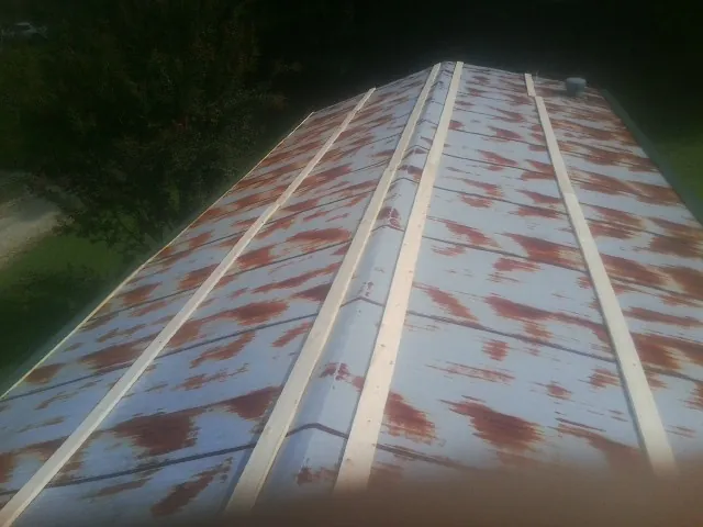Rusted metal roof panels with new wood purlins before replacement — Storm Damage Roof Repair in Sylvester by Roofing Brothers