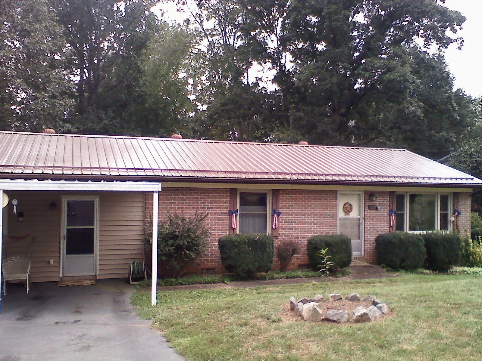 Bronze metal roof and carport on a brick ranch home — Roof Repair work by our crew in Sylvester