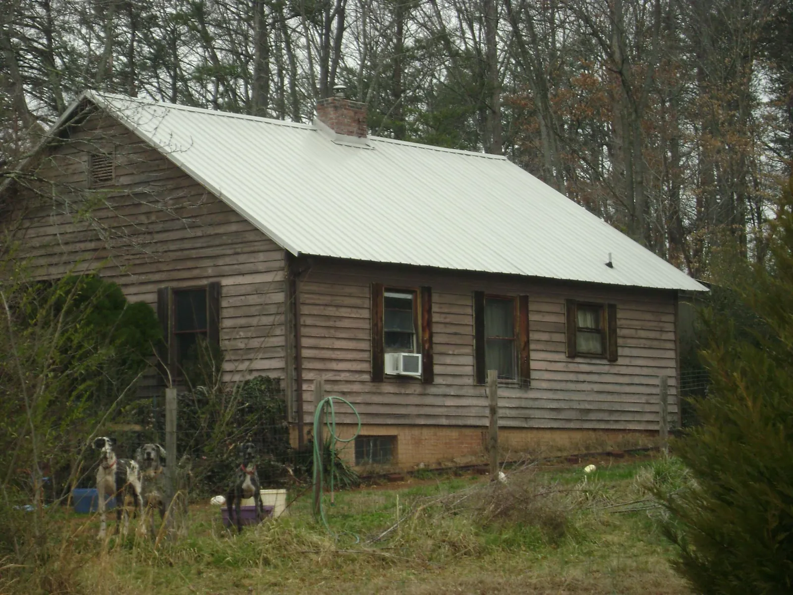 White metal roof on an old wood sided farmhouse, from a Metal Roof Installation job in Sylvester